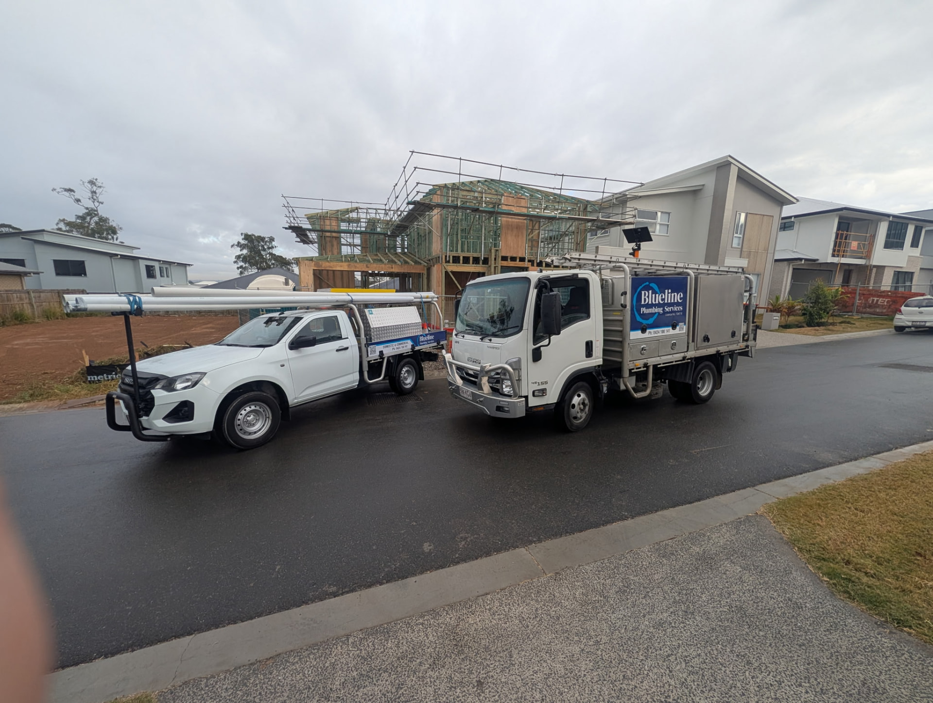 Blueline Plumbing Services vehicles at a construction project