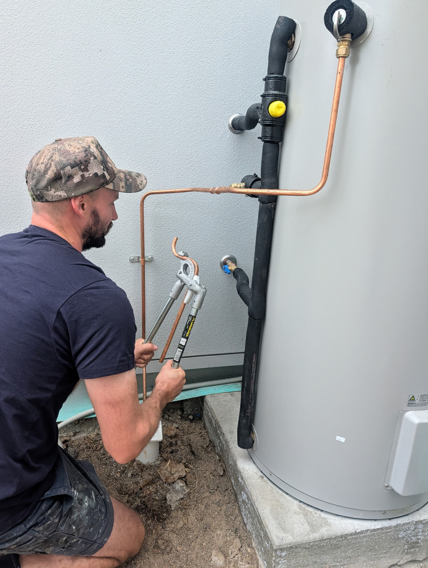 Blueline plumber installing copper pipework on a hot water system